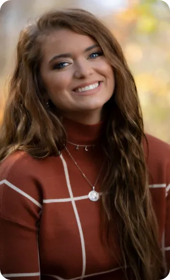 Woman in coat smiling outside