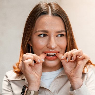 Closeup of woman putting on clear aligner
