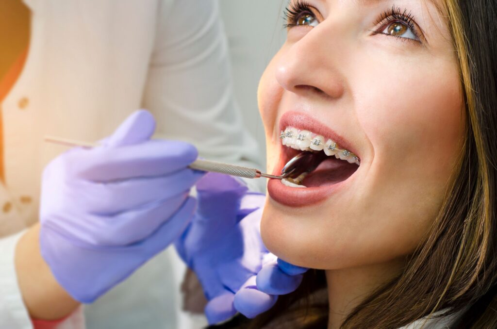 Woman having dental exam with braces visible on upper arch
